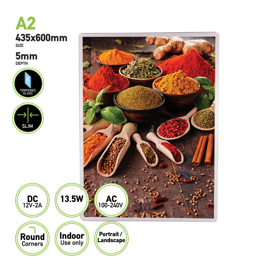 The Eledtric LED Light Box A2 Silver Slim Advertising Wall Mounted Display features a framed image showcasing spices in bowls and wooden spoons on a wooden surface, highlighted by vibrant powders and herbs. The display measures 435x600mm with a depth of 5mm and is ideal for indoor use. This frame can be mounted in both portrait and landscape orientations to beautifully illuminate the scene.